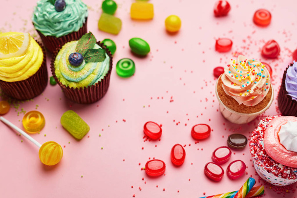 Sweets. Candy And Cupcakes On Pink Background. Colorful Candies And Cakes Closeup. High Resolution - Foto, afbeelding