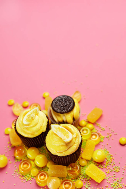 Cupcakes And Candies. Sweets And Lemon Cake Desserts On PInk Background. High Resolution - Фото, зображення