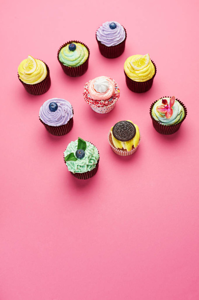 Colorful Cupcakes On Pink Background. Cake Desserts With Cream And Different Toppings. High Resolution - Фото, зображення