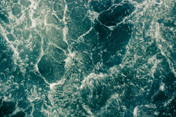 Denizin dalgaları, köpük ve kabarcıklar, yeşil arka plan yüzeyi - Fotoğraf, Görsel