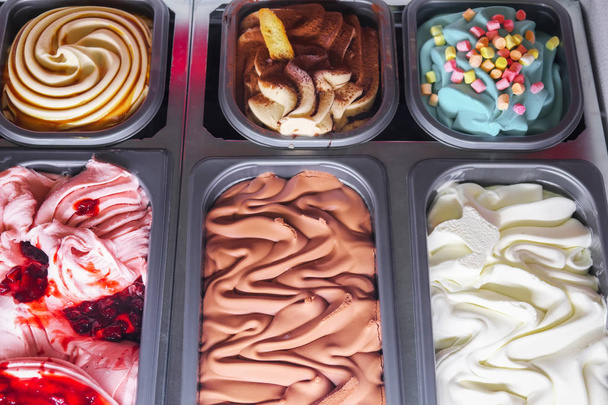 Delicioso helado de diferentes sabores y colores en una confitería
 - Foto, Imagen