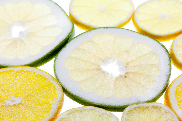 Abstract fruit pattern. Slices of citrus fresh fruits on white background - Photo, image