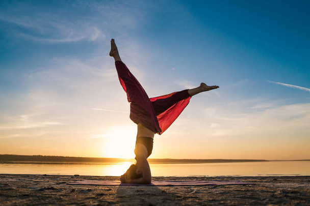 Gün batımında sahilde siluet yoga kadınla. - Fotoğraf, Görsel