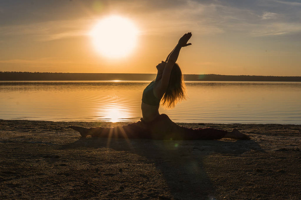 Silhouette yoga woman on the beach at sunset. - Photo, Image