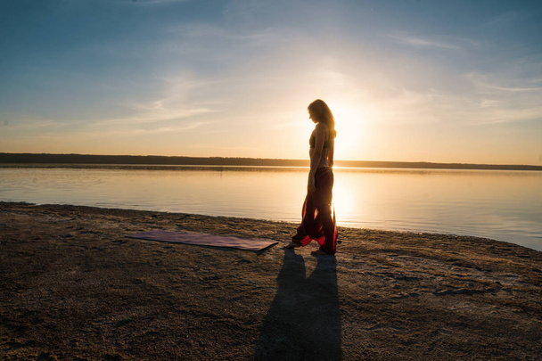 Silhouette yoga donna sulla spiaggia al tramonto
. - Foto, immagini