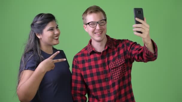 Young multi-ethnic business couple together against green background - Filmmaterial, Video