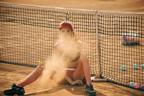 δραστηριότητα, αντίληψη του τρόπου ζωής. Αθλητισμός γυναίκα ρίχνει άμμο στο γήπεδο τένις - Φωτογραφία, εικόνα