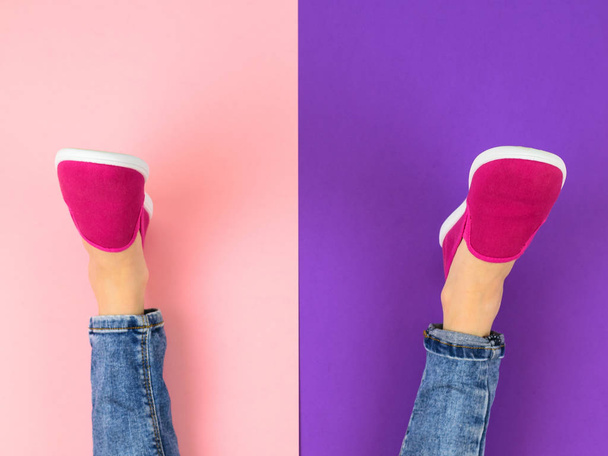 Nohy dívky v červené tenisky a roztrhané džíny na podlaze fialové a růžové. Pohled shora. Pojem moderní sportovní styl. - Fotografie, Obrázek