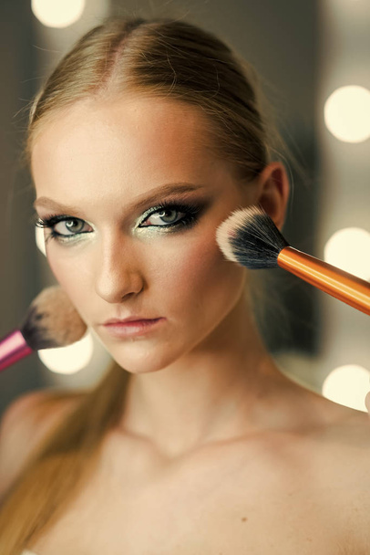 beauty salon. Girl makeup face with powder brushes in beauty salon. Girl skin, skincare, cosmetics - Foto, Imagen