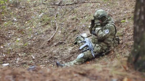 Soldados em camuflagem com armas de combate estão sendo disparados no abrigo da floresta, o conceito militar
 - Filmagem, Vídeo