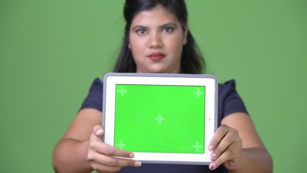 Young overweight beautiful Indian businesswoman against green background - Felvétel, videó