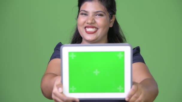 Young overweight beautiful Indian businesswoman against green background - Video, Çekim