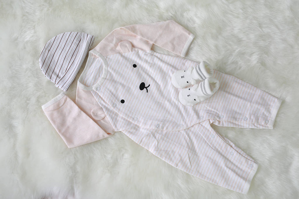 Bodysuits for newborn babies with socks on white fur background - Фото, изображение