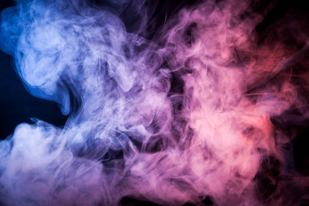 Παχύ πολύχρωμο μπλε, κόκκινο και ροζ καπνού πάνω σε μαύρο φόντο απομονωμένες. Φόντο από τον καπνό του vape - Φωτογραφία, εικόνα