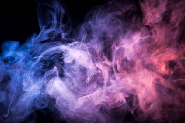 Πυκνοί καπνοί πολύχρωμα του μπλε, ροζ και μοβ χρώματα σε ένα μαύρο απομονωμένες φόντο. Υπόβαθρο του καπνού vap - Φωτογραφία, εικόνα
