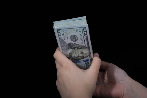 Hand-holding Amerikaanse dollar bankbiljetten geïsoleerd op witte achtergrond - Foto, afbeelding