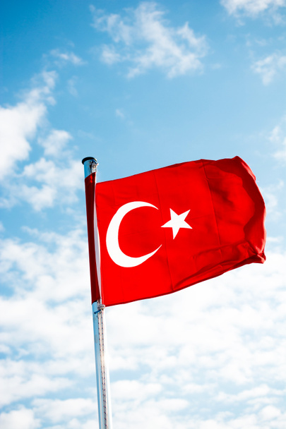 Красный турецкий флаг на шесте в облачном небе
 - Фото, изображение