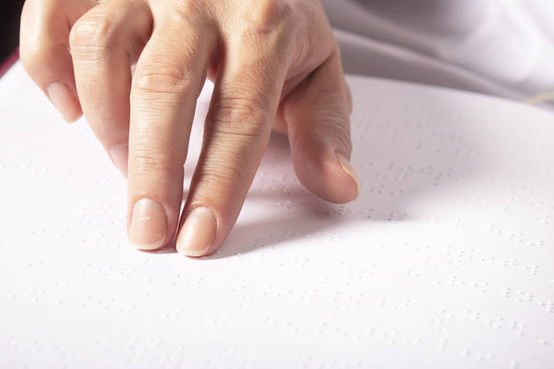 Τυφλή γυναίκα διάβασε βιβλίο γραμμένο σε Μπράιγ. Κοντινό άγγιγμα δαχτύλου στη γραφή braille - Φωτογραφία, εικόνα