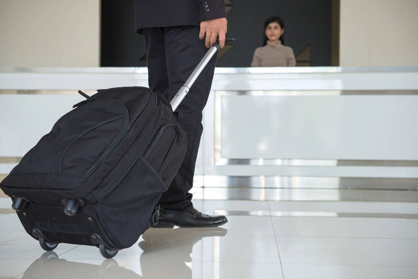 Homme d'affaires traîner bagages ou valise à pied dans le hall de l'hôtel
. - Photo, image