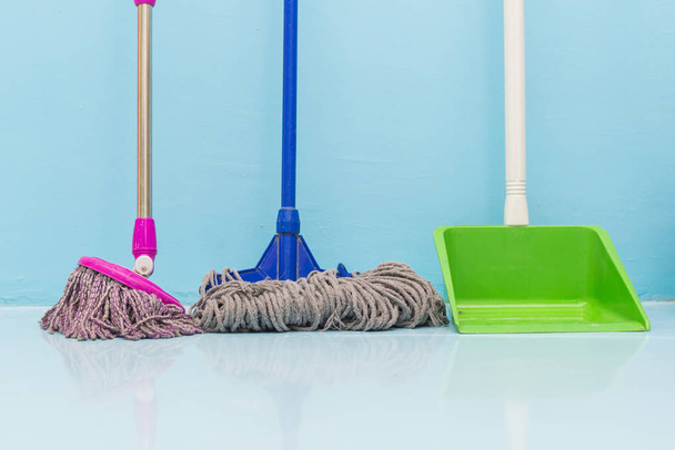 cleaning floor with wet mop and dustpan in room. - Photo, Image