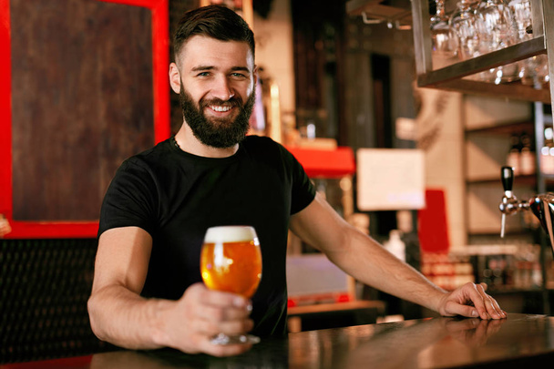 Craft Beer. Man Holding Glass With Beer In Pub, Bartender At Bar Counter. High Resolution. - 写真・画像