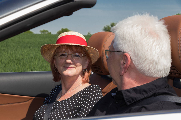 晴れた日に高級コンバーチブル車で 2 つの幸せな高齢者 - 写真・画像
