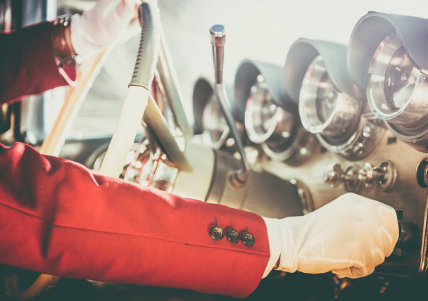 Κλασικό αυτοκίνητο οδήγηση θέμα. Καυκάσιος άνδρες φορώντας λευκά γάντια λαμβάνοντας Vintage συλλεκτικό αυτοκίνητο στο γύρο δοκιμής. Το χέρι στο τιμόνι Closeup φωτογραφία. - Φωτογραφία, εικόνα