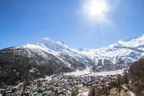 Švýcarské vesnice obklopené zasněžené horské pásmo v Saas Fee - Fotografie, Obrázek