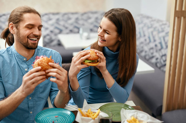 People Having Dinner, Eating Burgers At Cafe. Friends Eating Fast Food In Restaurant. High Resolution. - Fotó, kép