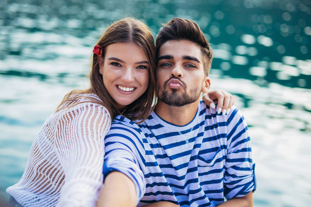 Couple in love enjoying summer time at sea making faces - 写真・画像