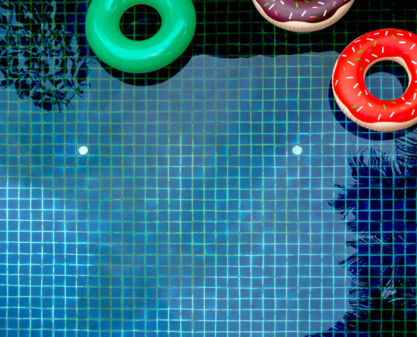 Kolorowe pierścienie Float basen są pływające na tle basen, koncepcja lato - Zdjęcie, obraz