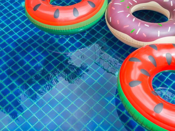 Цветные плавающие кольца бассейна плавают на фоне плавательного бассейна, летняя концепция
 - Фото, изображение