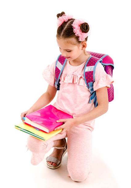 Portrait of smiling happy school girl child with school bag backpack and books isolated on a white background education concept - Фото, зображення
