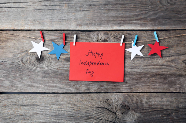 Paper stars and inscription Happy Independence Day on wooden background - Photo, Image