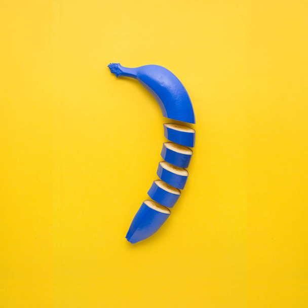Creative still life photo of cut blue banana on yellow background. - Φωτογραφία, εικόνα