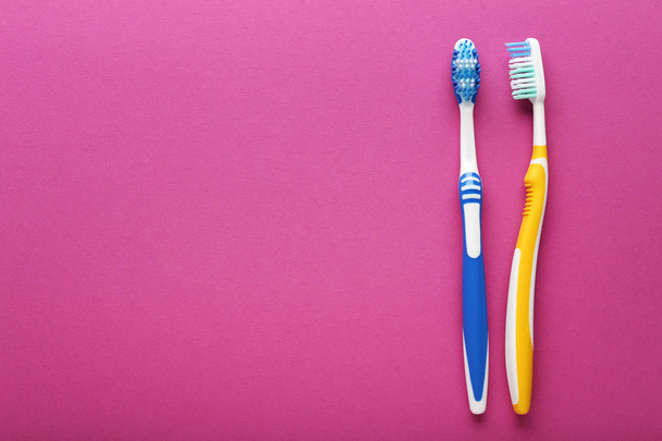 Colorful plastic toothbrushes on pink background - Φωτογραφία, εικόνα