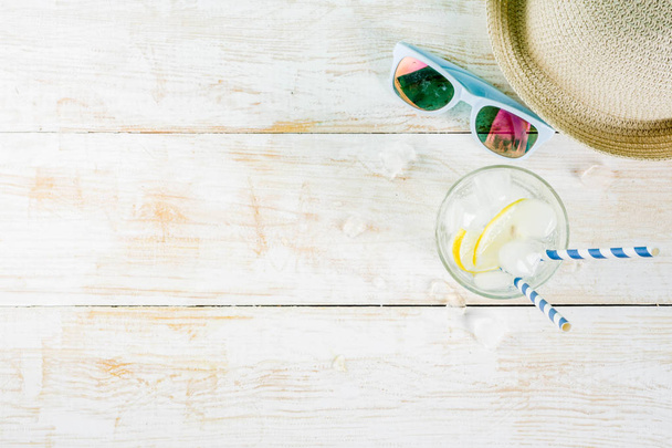 Zomervakantie vakantie concept achtergrond, hoed, zonnebril, iced drankje (limonade, mojito), witte houten achtergrond kopie ruimte bovenaanzicht - Foto, afbeelding