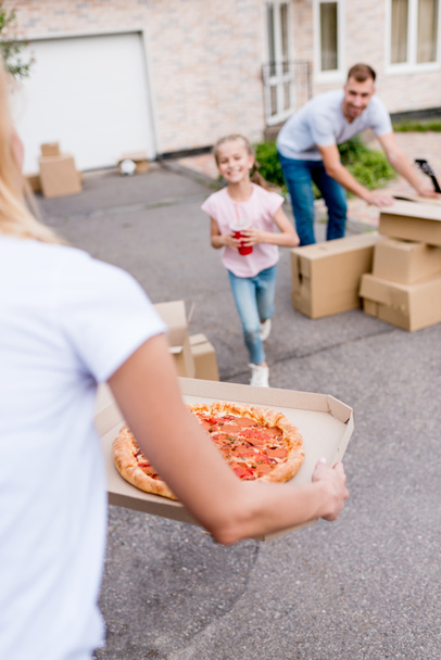 imagen recortada de mujer sosteniendo pizza e hija con taza de cola corriendo hacia ella
 - Foto, Imagen