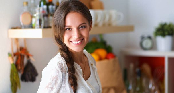 Jeune femme debout près du bureau dans la cuisine - Photo, image