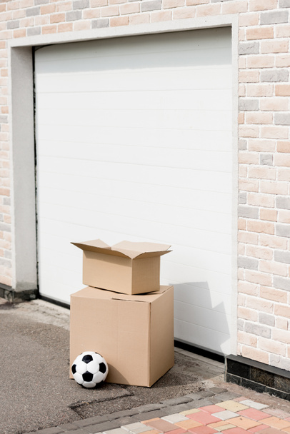 close up shot of boxes, soccer ball in front of garage gate - Foto, Imagen