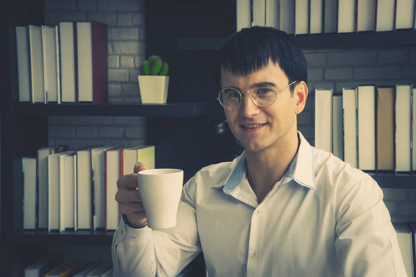 Felnőtt férfi élvezi reggeli kávé az irodában - Fotó, kép