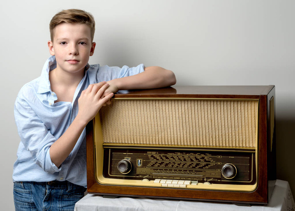 Boy teenager near old radio. - Valokuva, kuva