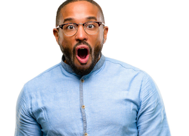 African american man with beard happy and surprised cheering expressing wow gesture isolated over white background - Foto, imagen