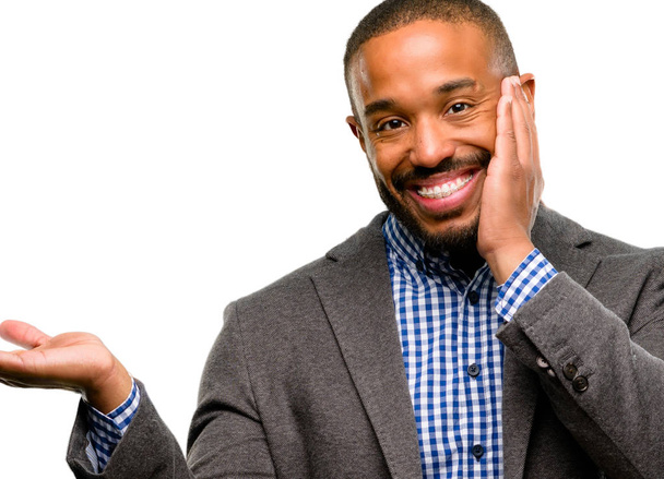 Afrikanisch-amerikanischer Mann mit Bart hält etwas in der leeren Hand isoliert über weißem Hintergrund - Foto, Bild