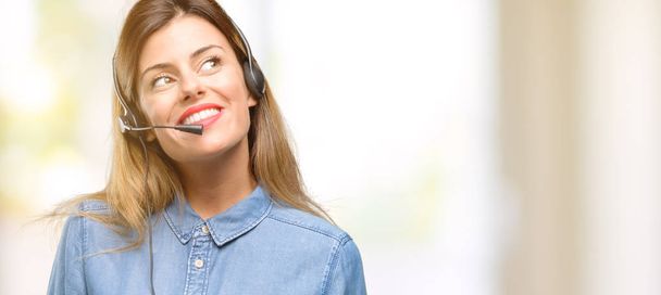 Beraterin einer Callcenter-Frau mit Kopfhörer denkt nach und blickt auf und äußert Zweifel und Verwunderung - Foto, Bild