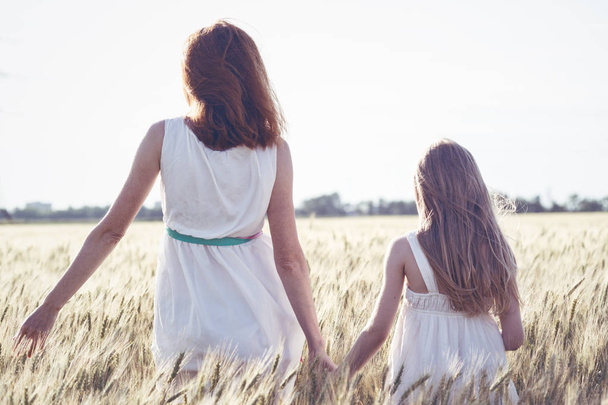 happy summer and vacation. Family - mother with her daughter in a wheat fiel - Foto, Bild