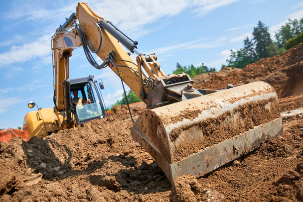 Μπουλντόζα σε ανοικτό πεδίο operationexcavator εργοτάξιο - σκάβουν τα θεμέλια για το σπίτι - Φωτογραφία, εικόνα