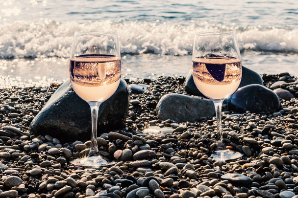 Two glasses of pink wine near sea at sunny morning - Photo, image