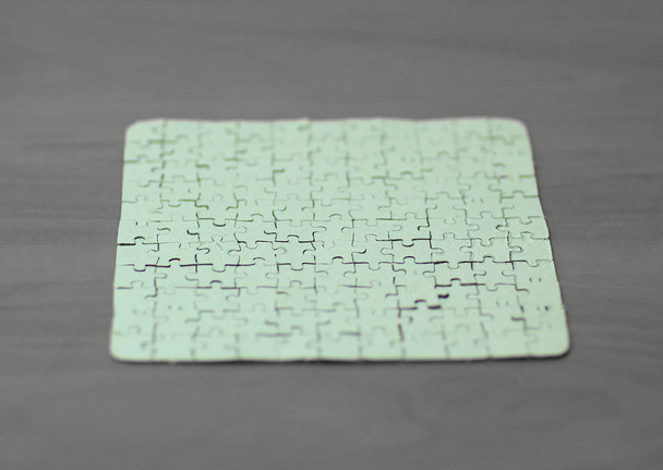 blank card collected from puzzle pieces on wooden background - Fotó, kép