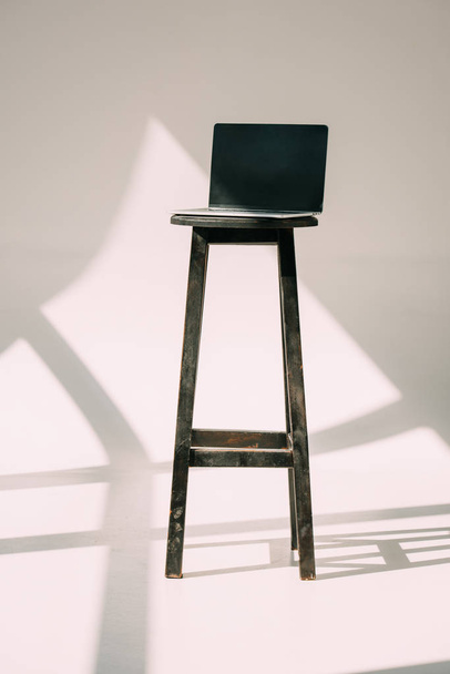 laptop with blank screen on wooden stool on grey - Photo, image